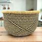 Round Bolga storage basket with a black and natural diagonal pattern and no handles