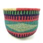 Front view of the round Bolga storage basket with teal, red, navy and green bands with a pale diamond band, and no handles on a white background