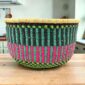 Round Bolga storage basket with teal, navy and pink stripes and no handles
