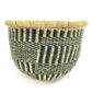 Front view of the navy and natural round Bolga basket on a white background