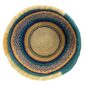 Top-down view inside the teal and yellow round Bolga basket, showing the coiled base