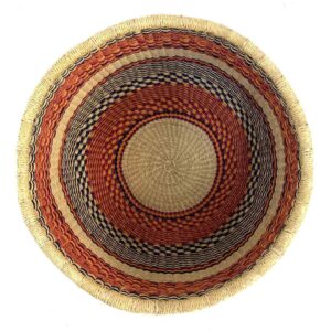Top-down view inside the orange and black round Bolga basket, showing the coiled base