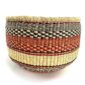 Front view of the orange and black round Bolga basket on a white background