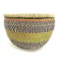 Front view of the green and black round Bolga basket on a white background