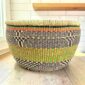Round Bolga basket with no handles in green and black, handwoven from elephant grass