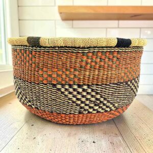 Round Bolga basket with no handles in rust and black, handwoven from elephant grass