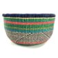 Front view of the green and pink round Bolga basket on a white background