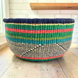 Round Bolga basket with no handles in green and pink, handwoven from elephant grass