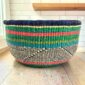 Round Bolga basket with no handles in green and pink, handwoven from elephant grass