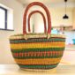 Mega Wawa basket with teal, rust, gold and green striped bands, leather handles