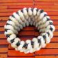 Handmade 4 strand cowrie shell bracelet flat lay showing white and black bead details on wood background