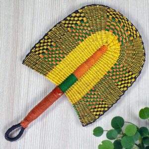 Woven fan resting on natural surface.