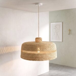 Woven bolga lampshade hanging near a window, fully undyed natural straw
