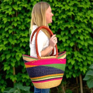 woven-market-basket-LH-234-pasture (3) Woman carrying a long handle Bolga market basket on her shoulder, showcasing its size and comfortable strap length.