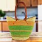 Long handle market basket with broad bands of warm and fresh tones and leather-wrapped handles