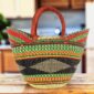 Classic market basket with bold multicolour bands around a dark diamond pattern and leather-wrapped handles