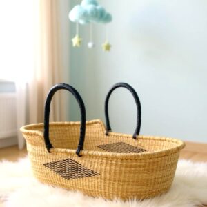 Handwoven Moses basket made from natural elephant grass, placed on a soft rug in a nursery setting, showcasing eco-friendly craftsmanship and style.